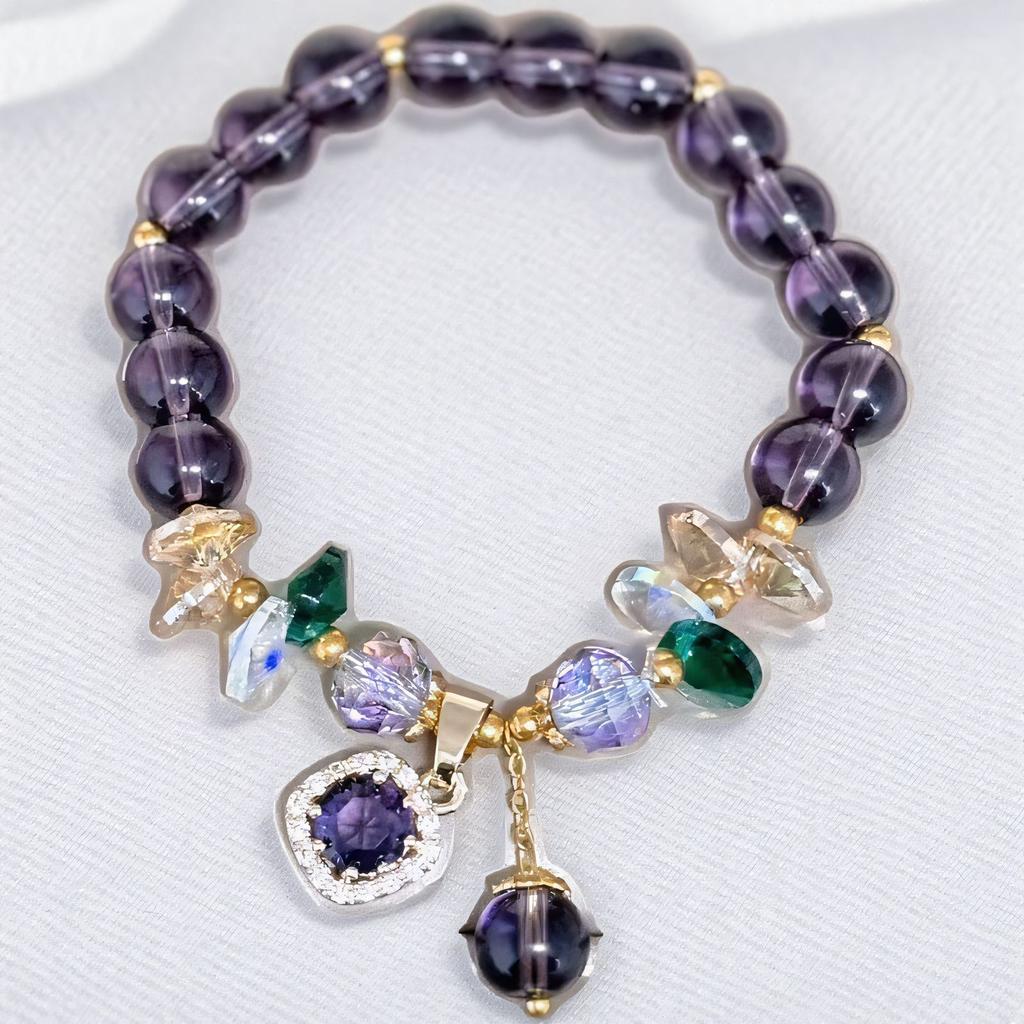 Amethyst crystal bracelet with gold charm and colorful gemstones on a white background