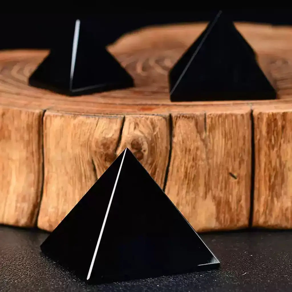 Black Obsidian Pyramids on Wood Background