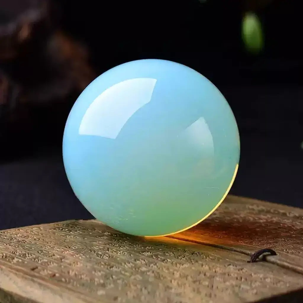 Blue Opal Crystal Sphere on Wood Table