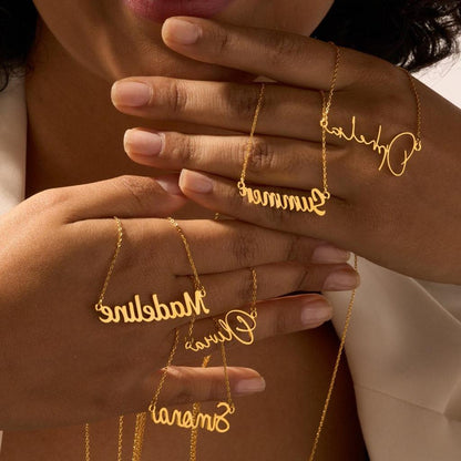 Hands Holding Gold Script Name Necklaces