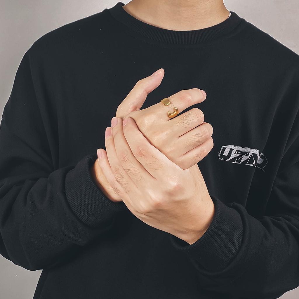 man wearing black sweatshirt with gold ring on finger